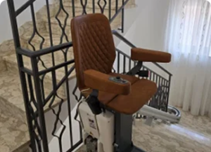 Sitz-Treppenlift mit braunem Ledersitz an einer Innentreppe in NRW